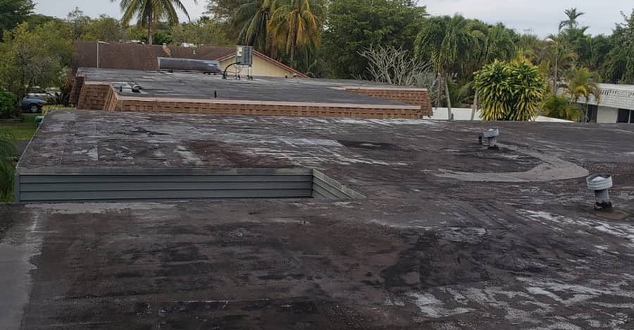 Before: dark, stained flat roof